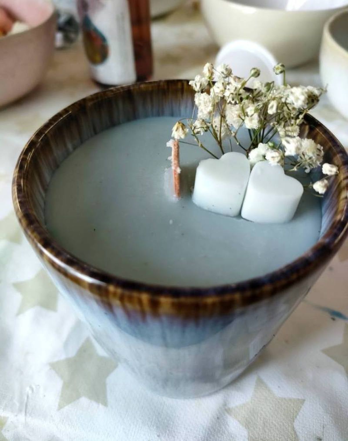 Vela artesanal en color azul con mecha de madera.