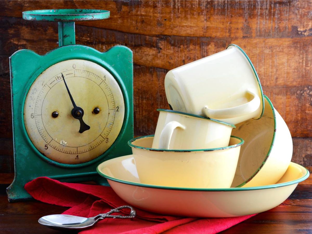 Una báscula antigua y vajilla esmaltada aportan autenticidad y nostalgia a la decoración retro de la cocina.