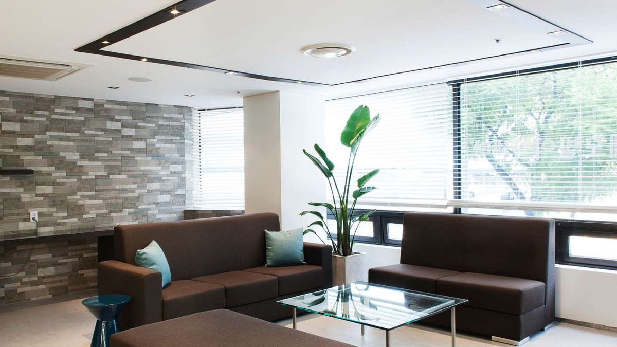 Salón decorado en marrón con mesa de cristal.