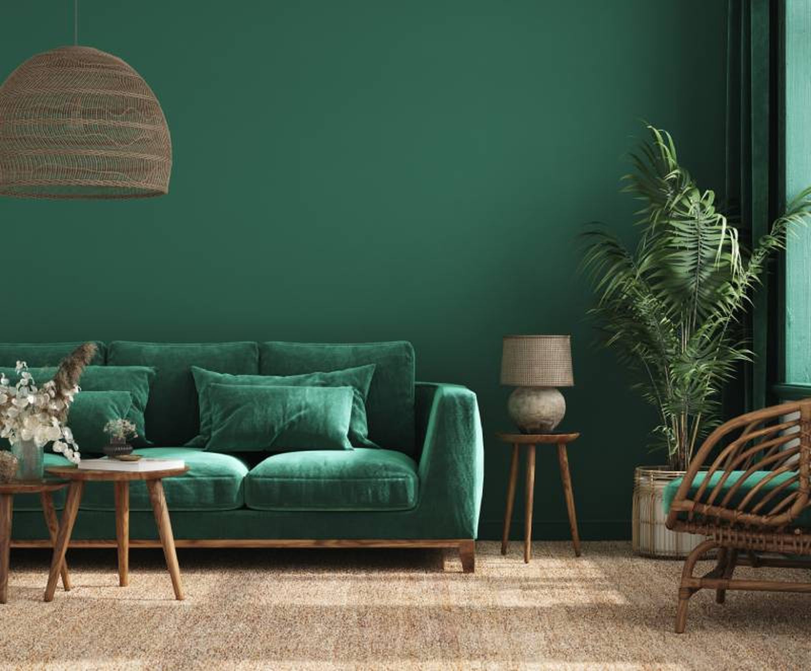 Salón con pared y sofá de terciopelo en verde bosque.