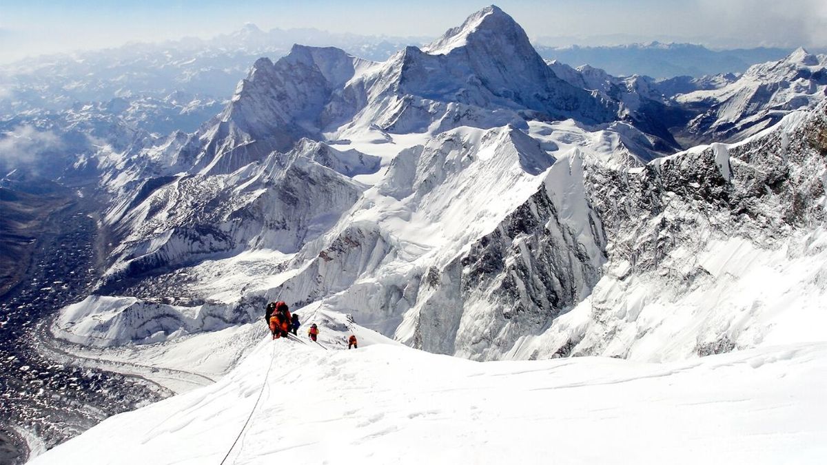personas escalando el monte everest con nieve