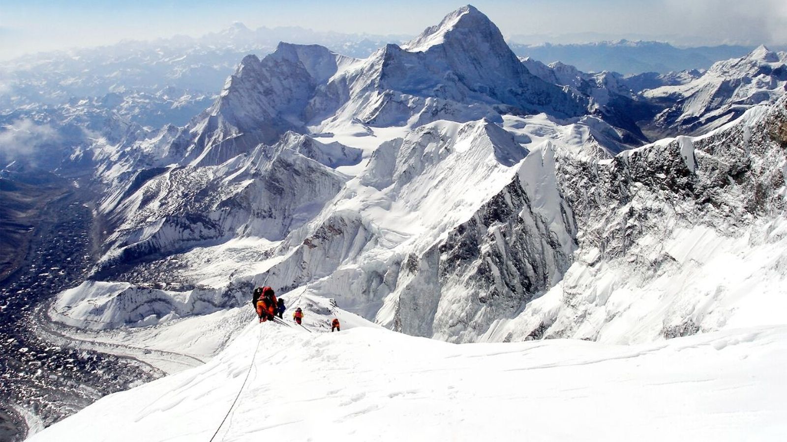 personas escalando el monte everest con nieve