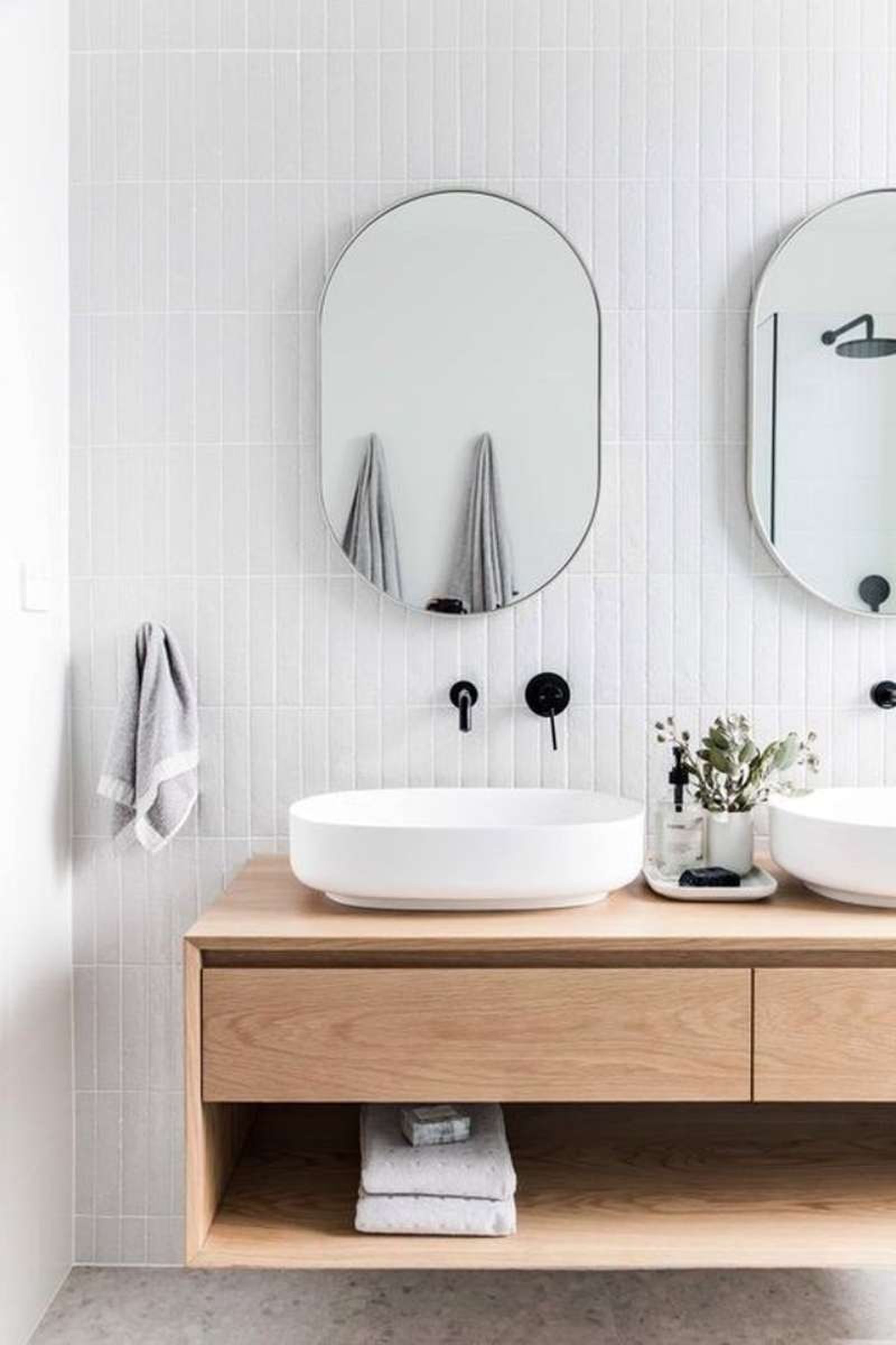 Baño de estilo nórdico con dos lavabos y grifería negra.