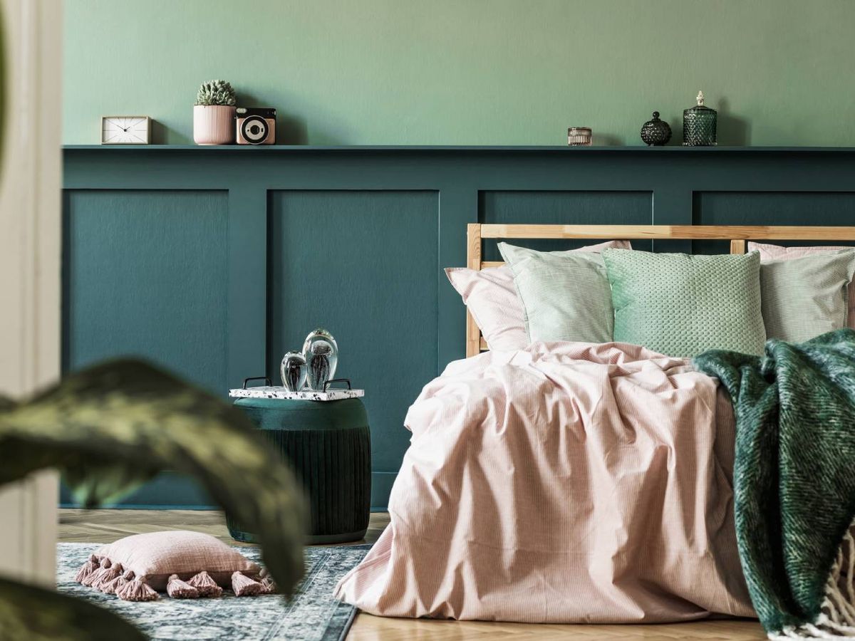 El verde en el cabecero aporta profundidad y calma al dormitorio.