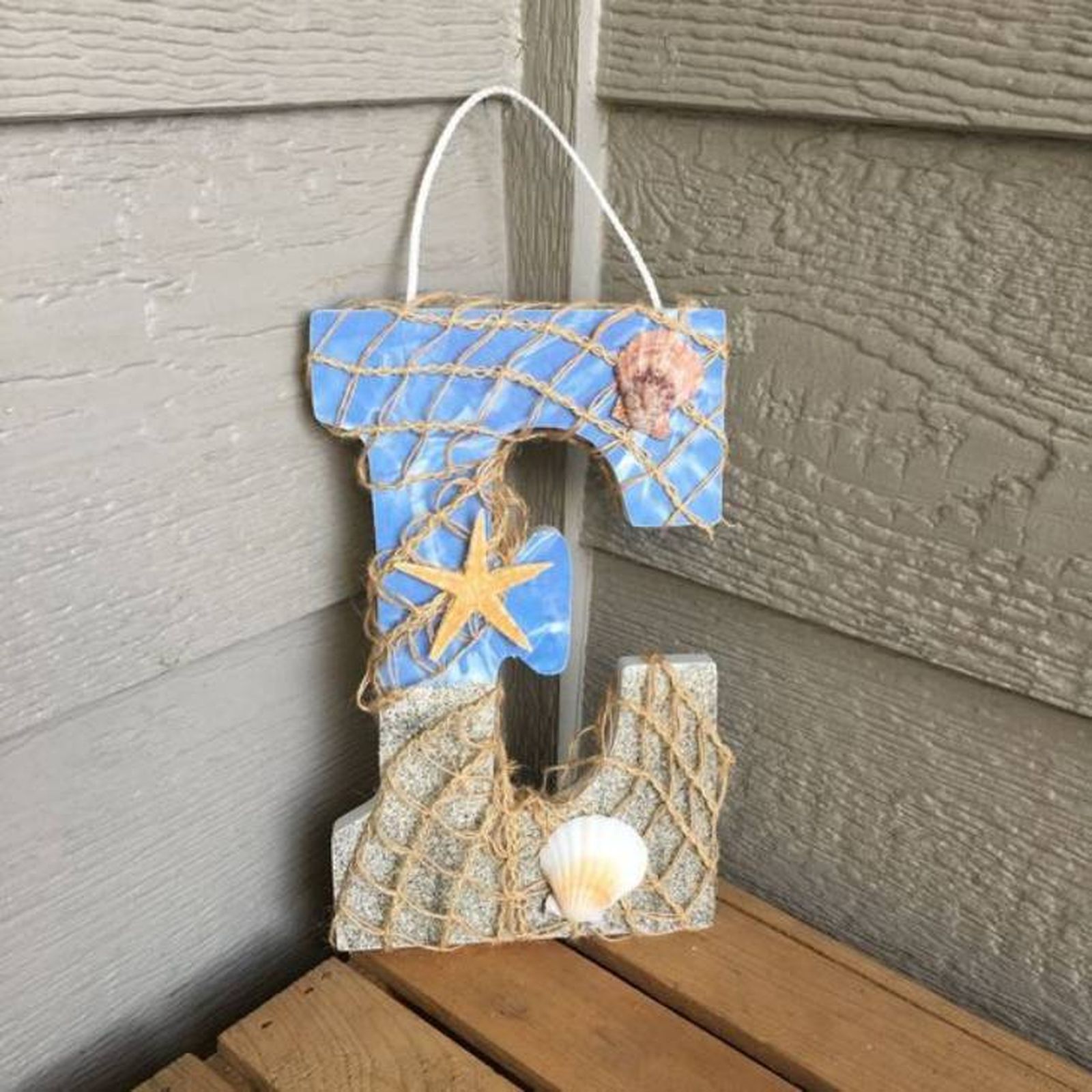 Letra E de estilo marinero decorada con cuerda de fibras naturales y conchas.