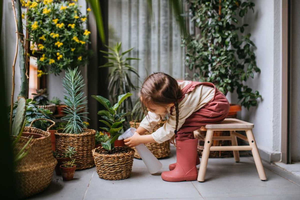 Pequeña regando plantas.