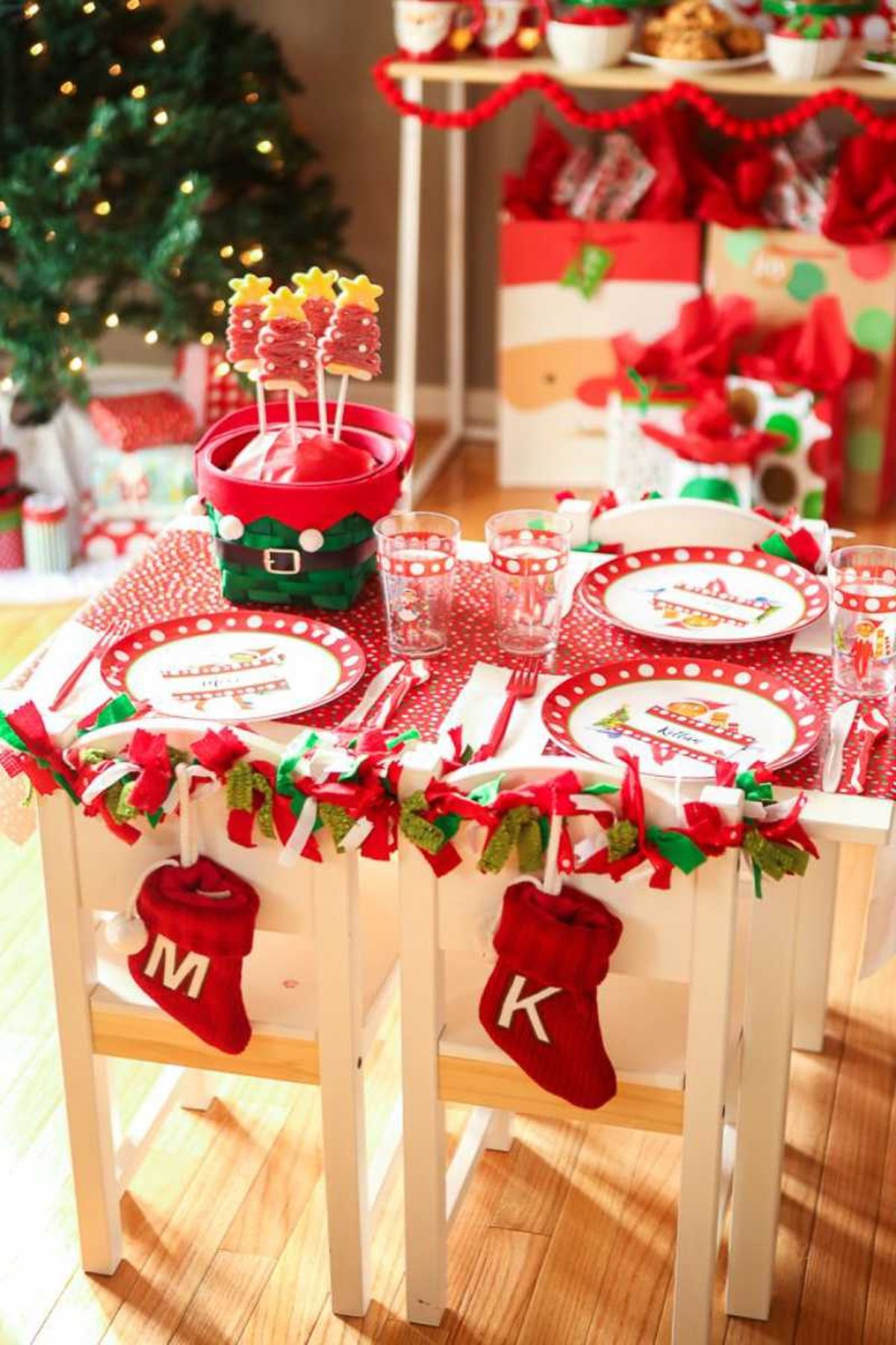 Mesa navideña para niños con sillas decoradas.