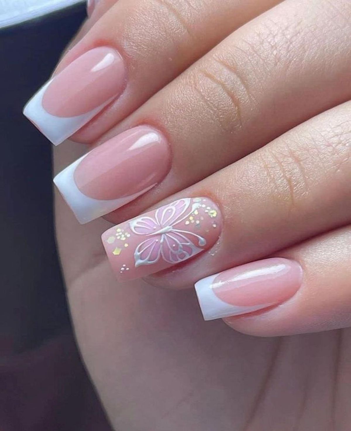 Uñas francesas con diseño de mariposa.