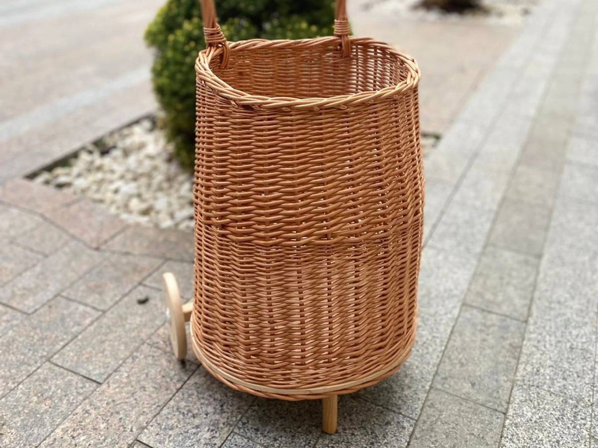 Cesto de mimbre alto con ruedas, ideal para transportar la compra o ropa.