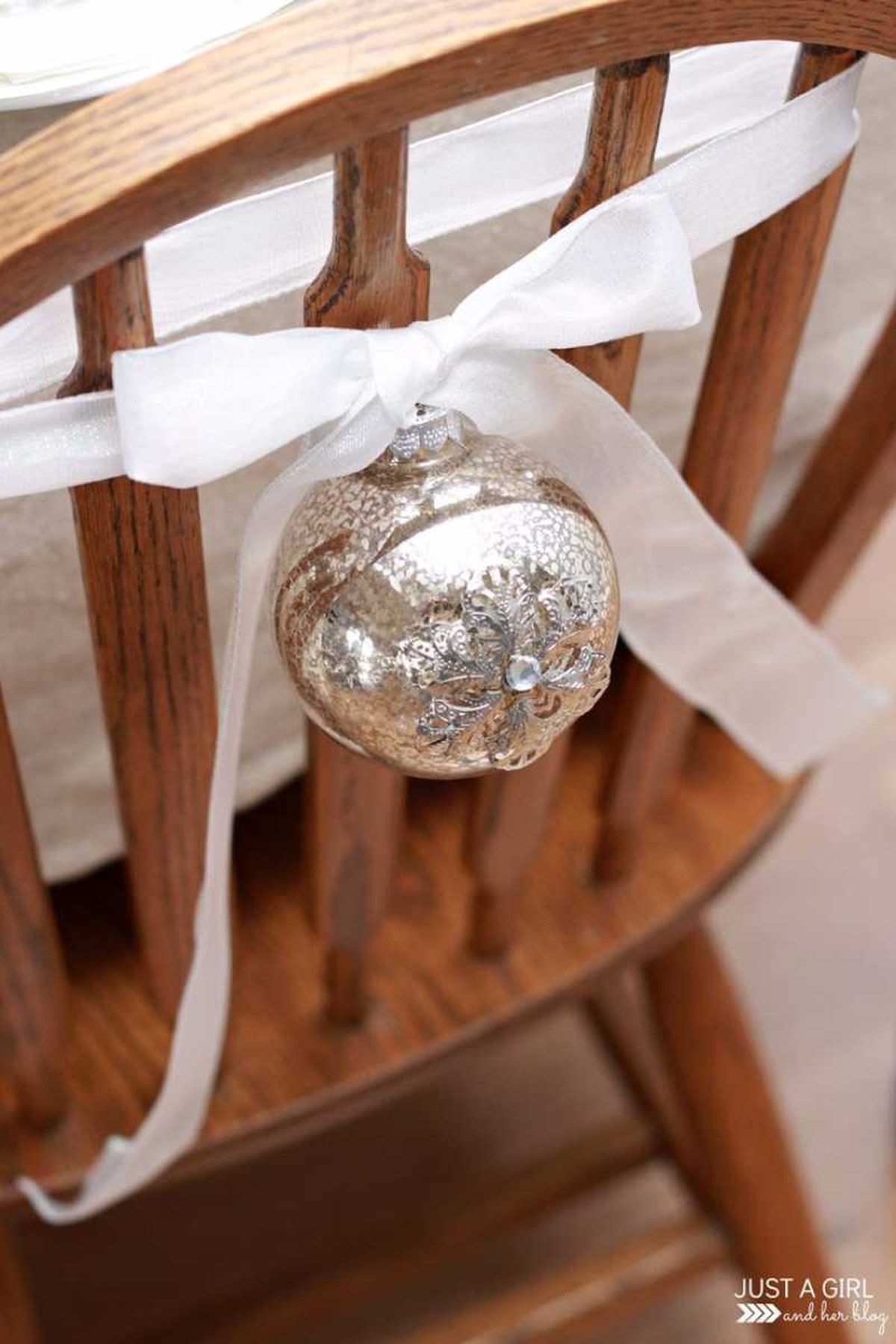 Silla decorada con una bola de Navidad plateada.
