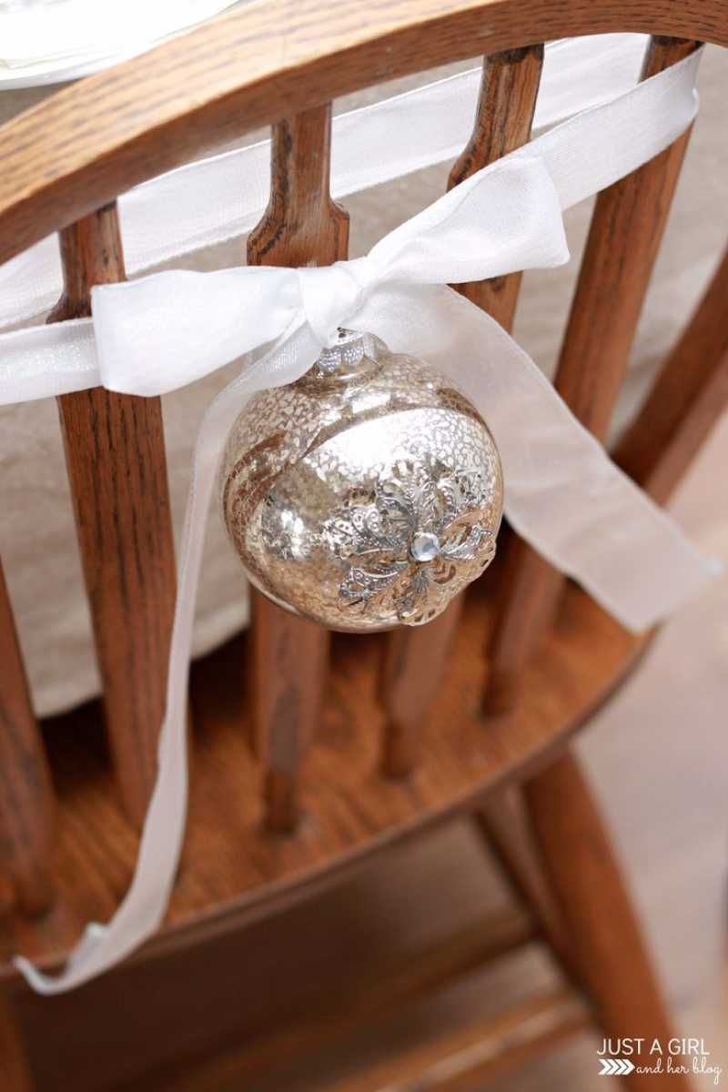 Silla decorada con una bola de Navidad plateada.