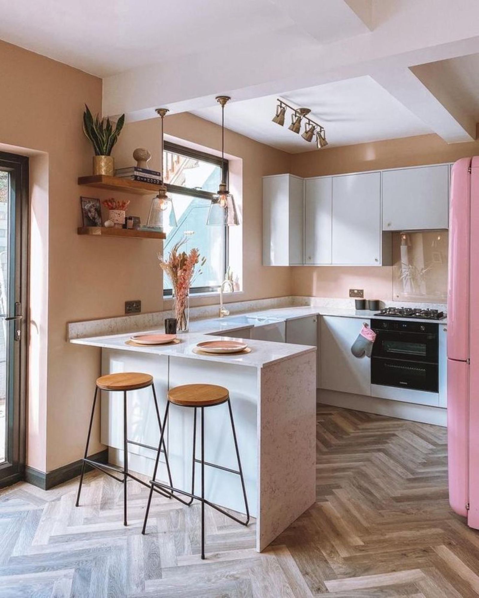 Cocina con península con barra desayunadora y taburetes altos.