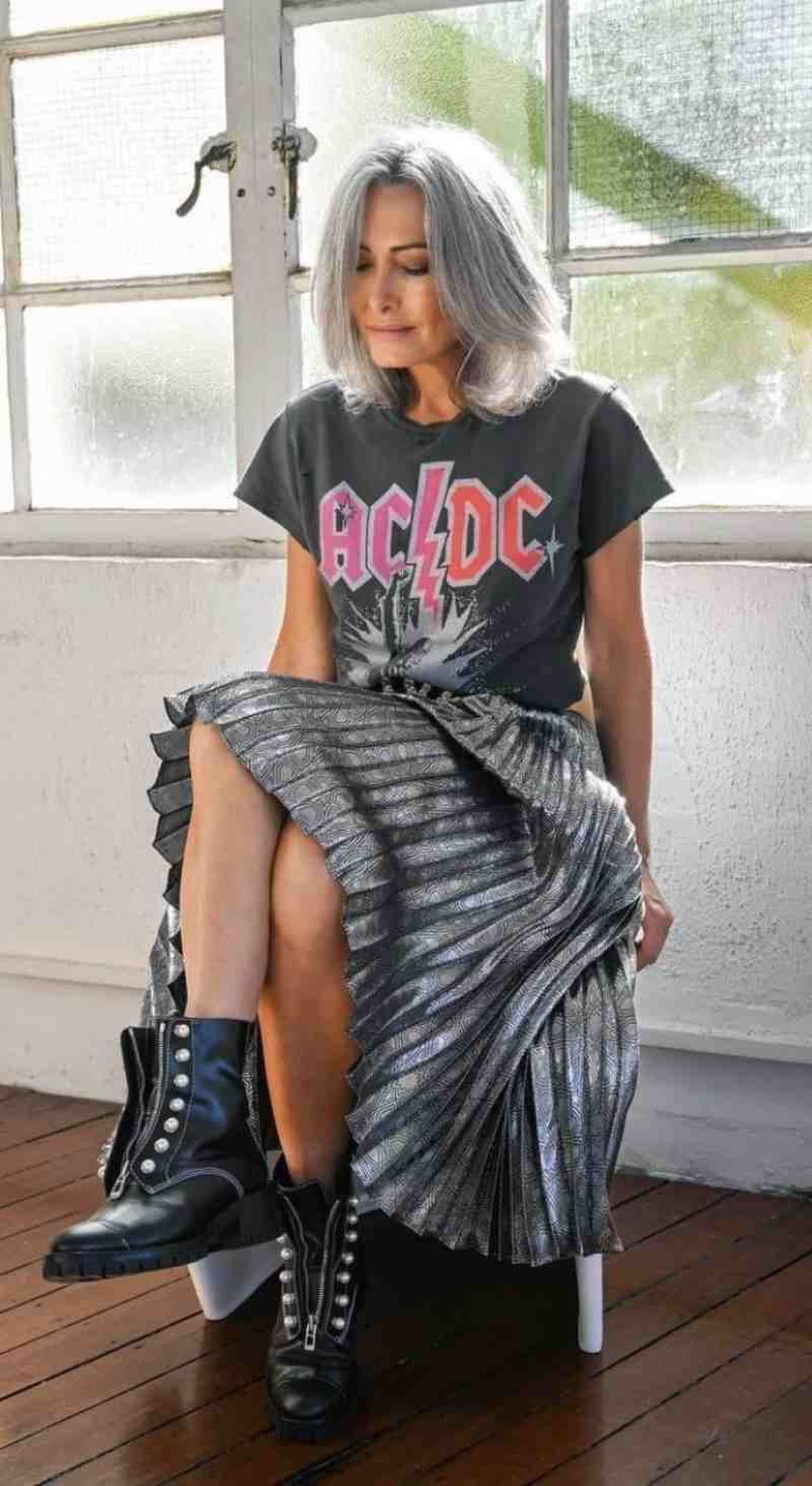 Camiseta de AC/DC con falda plisada y botas de estilo militar