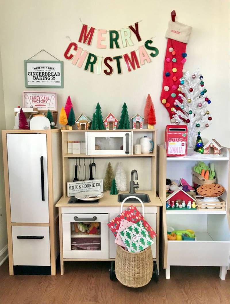 Cocinita de madera de juguete con decoración navideña.