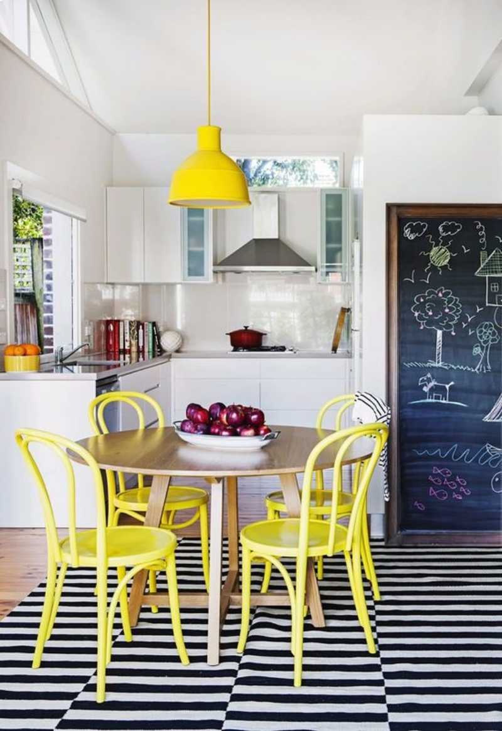 Cocina con sillas amarillas pintadas con pintura a la tiza.