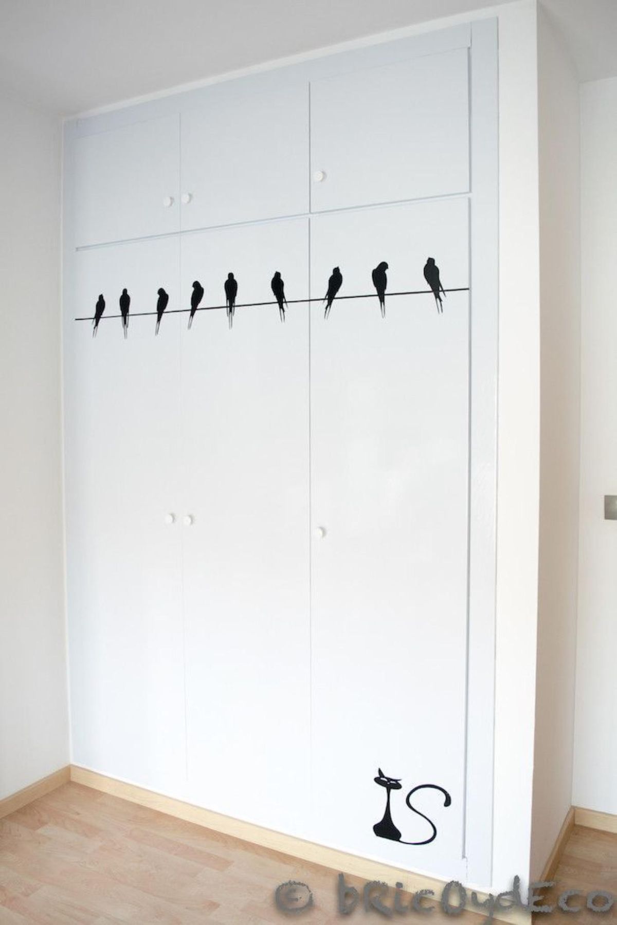 Armario empotrado forrado con vinilo de corte de pájaros y un gato.