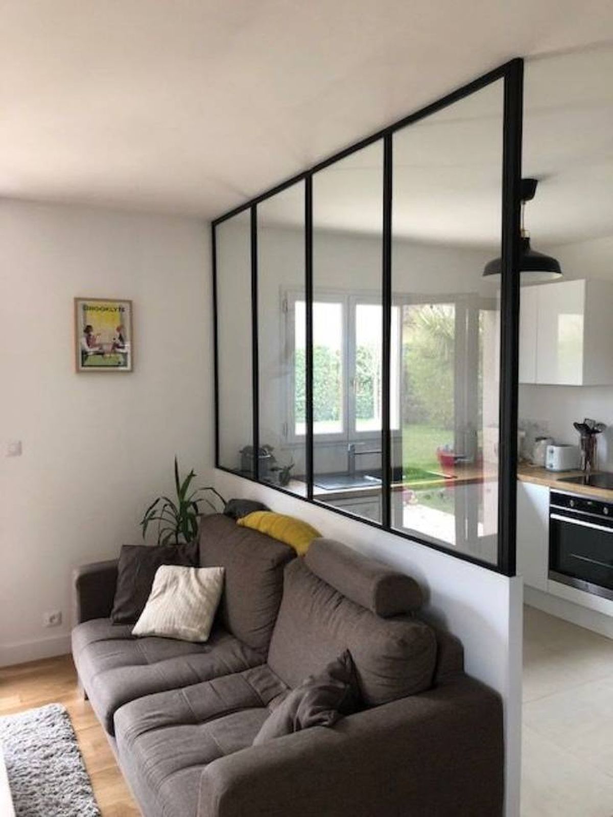 Cocina semiabierta al salón con sofá gris.