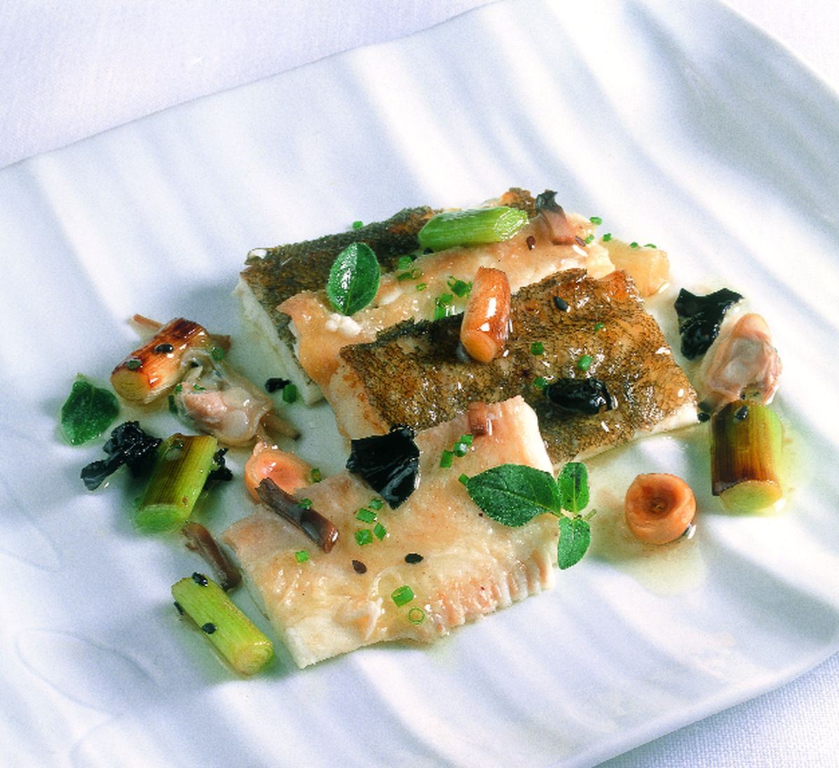 Lenguado en jugo de chirlas a la salvia con sésamo, nueces de macadamia y hortalizas salteadas