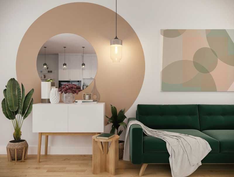 Salón organizado con sofá verde de terciopelo.