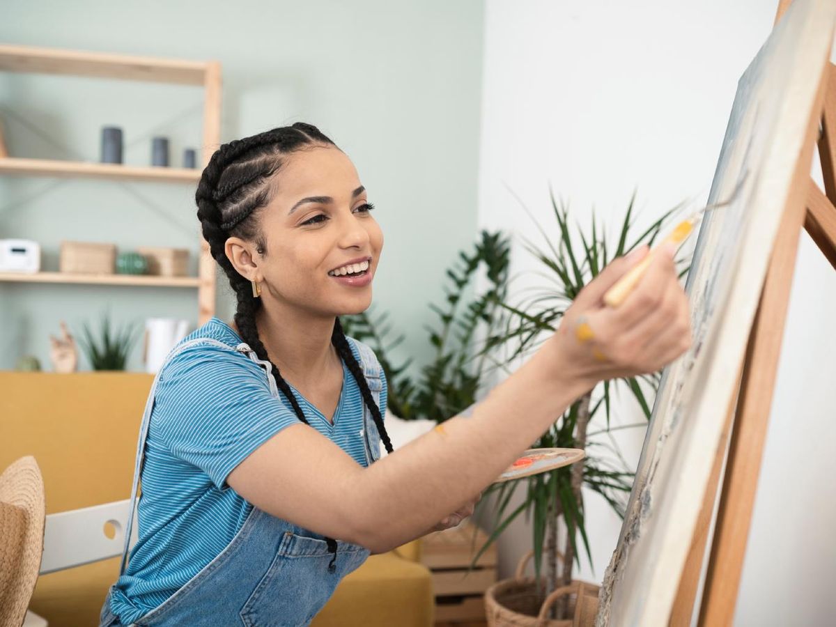 Mujer pintando un cuadro en casa.