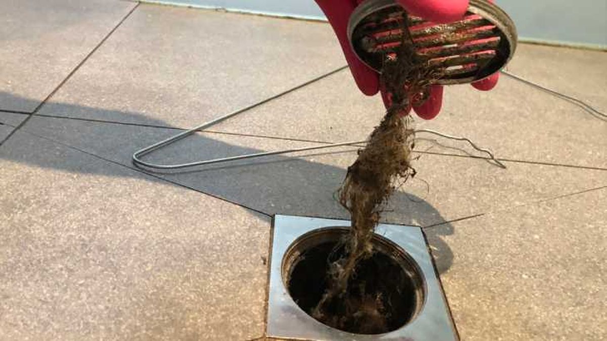 Retirando restos de suciedad de un bote sifónico