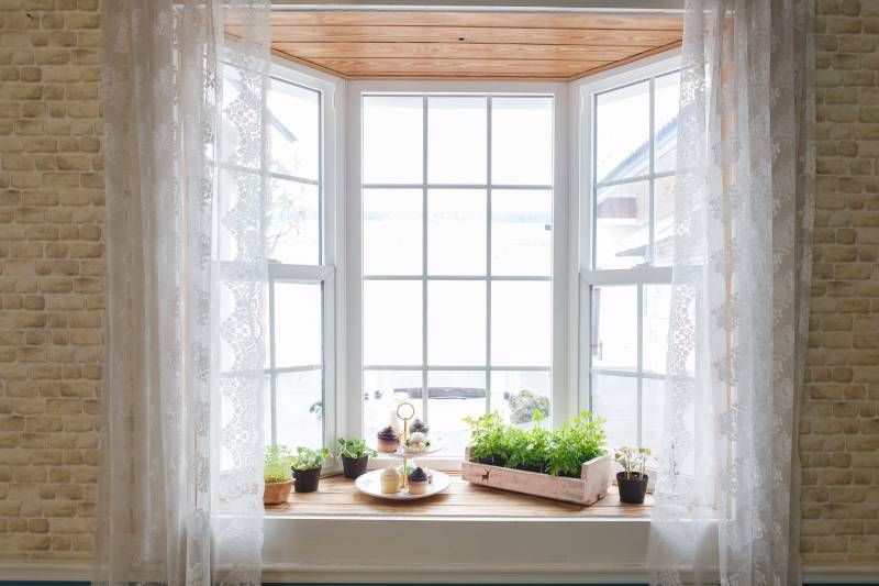 Rincón acogedor en una ventana con cortina.