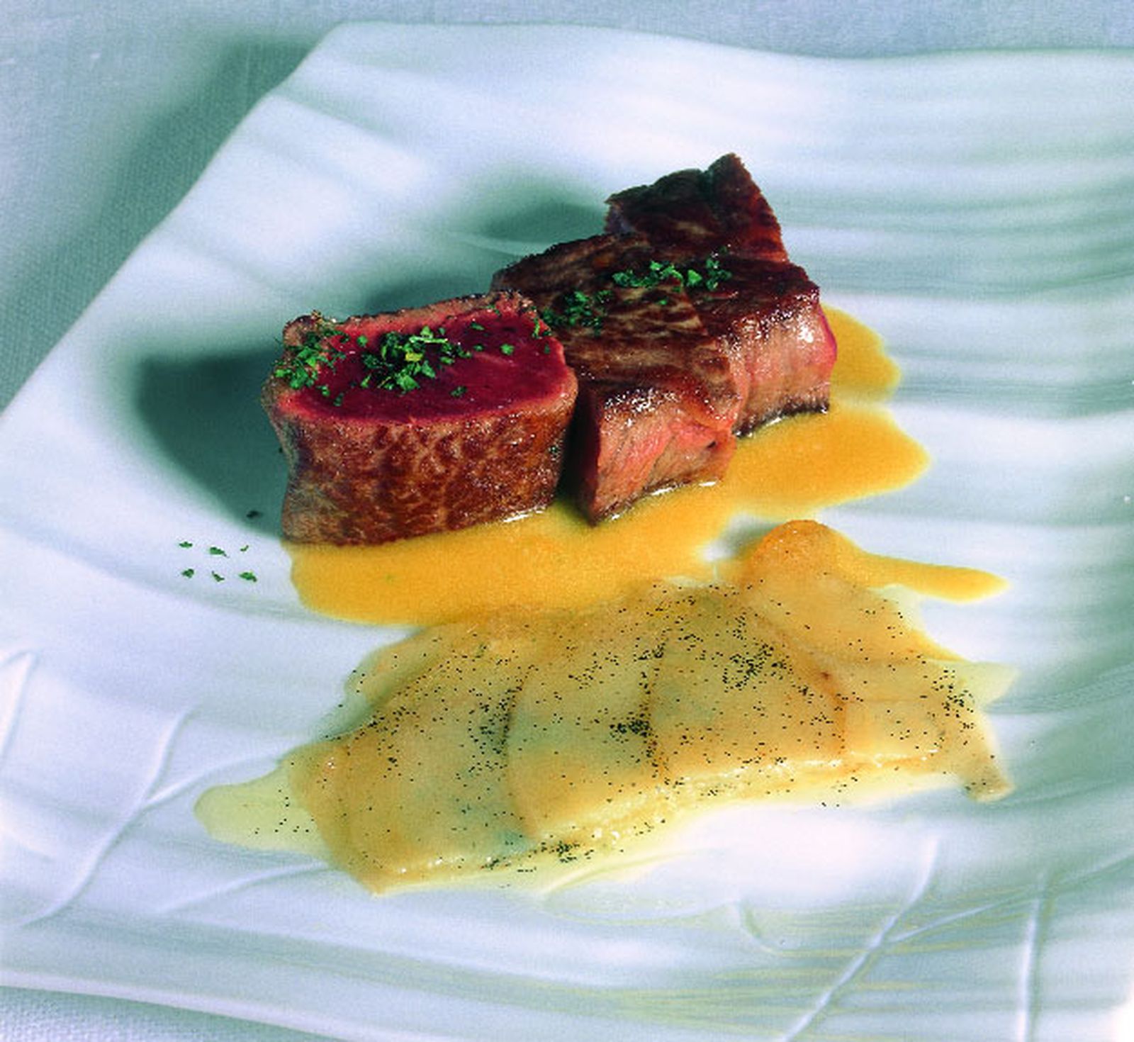 Entrecot de buey con flores de sal, salsa de pimiento amarillo y patatas avainilladas