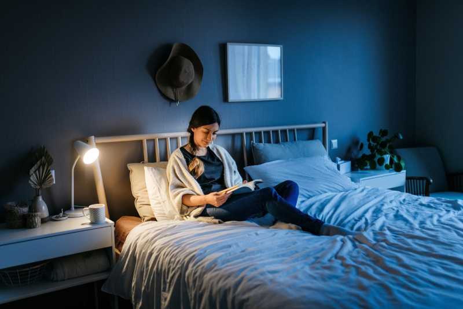 Mujer leyendo relajada en la cama.
