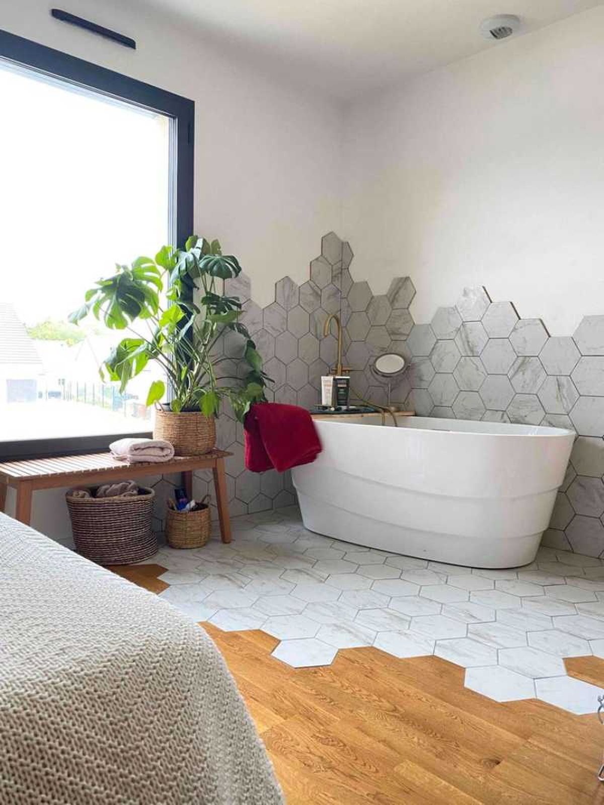 Baño con suelo con transición de madera y azulejos.