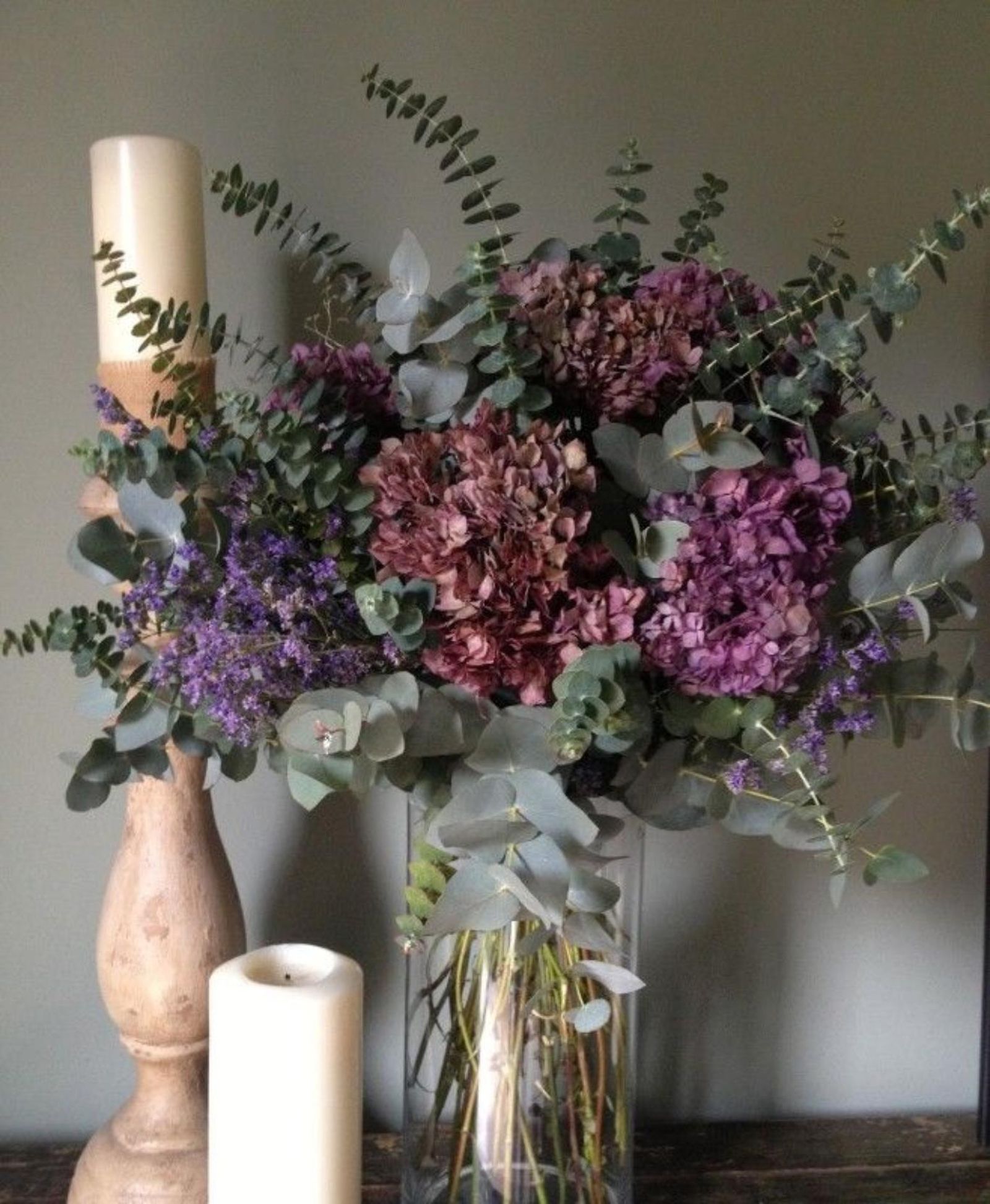Velas elegantes y jarrón con flores.
