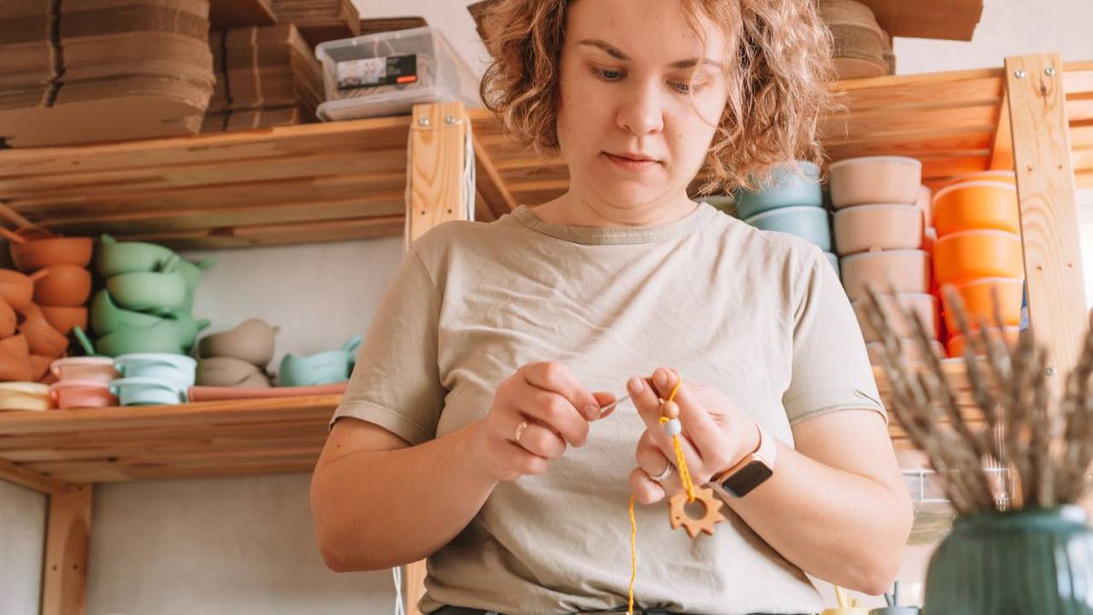 Mujer haciendo un nudo en un collar.