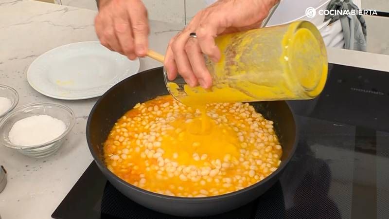 Añade el puré de verduras a la sartén con las alubias