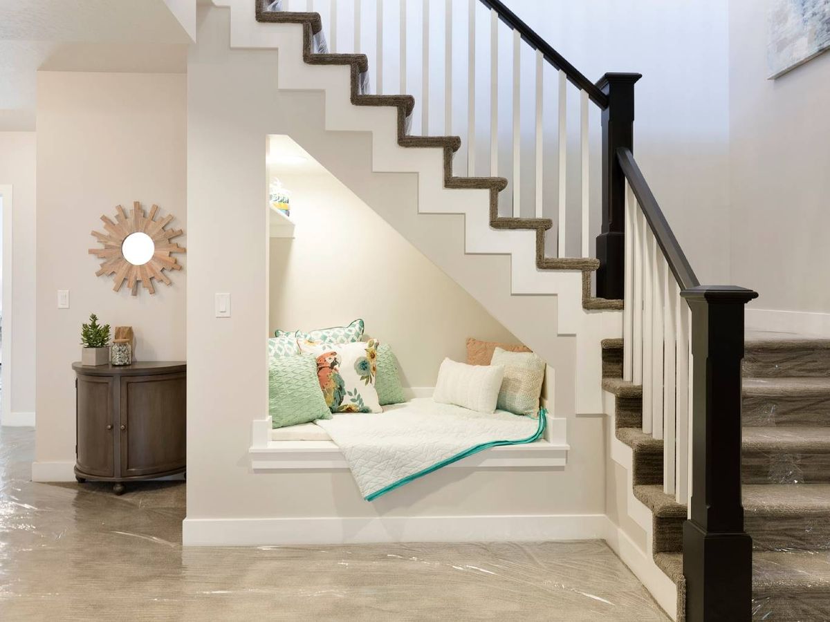 Crea un rincón de lectura confortable aprovechando el hueco de la escalera.