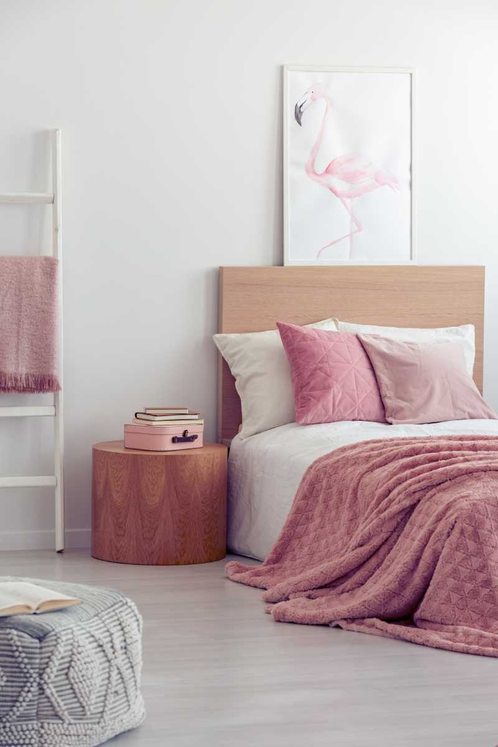 Dormitorio pequeño decorado en tonos rosas.