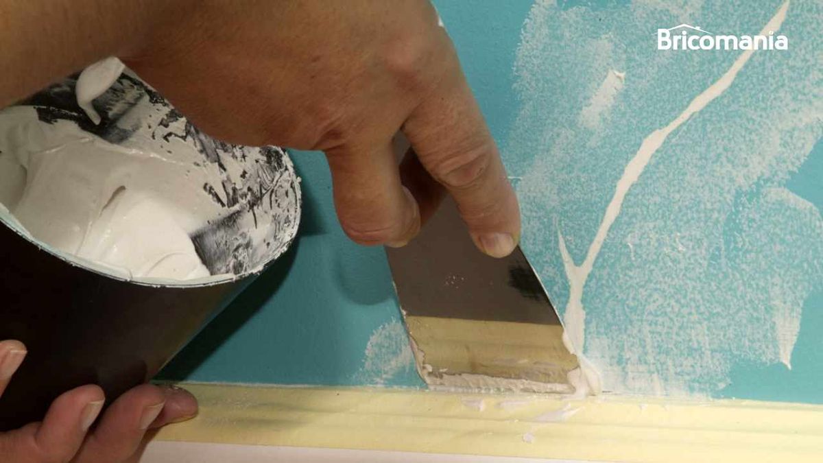 Persona reparando una grieta de la pared