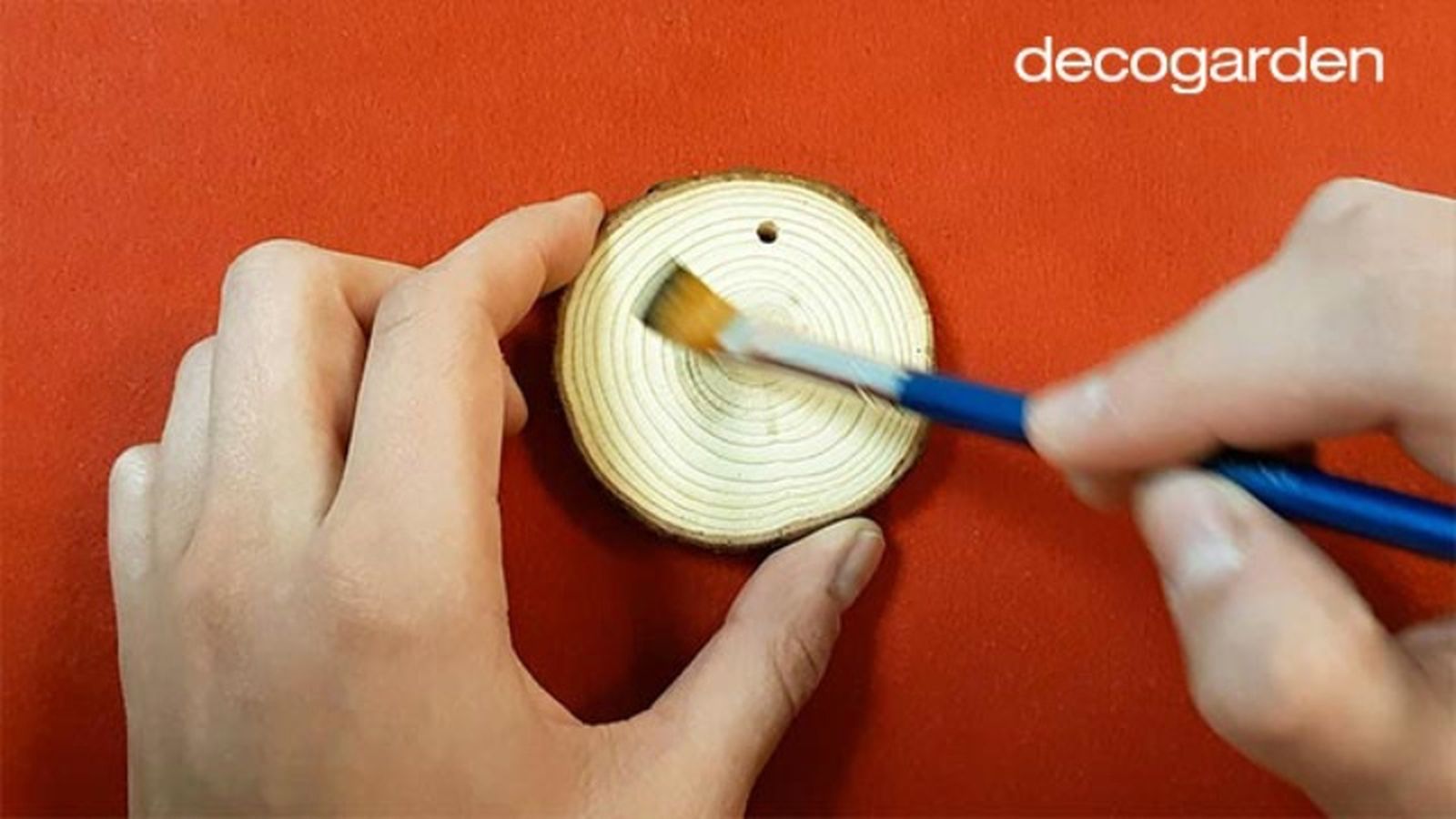 Quitando el polvo y astillas de los discos de madera con un pincel antes de pintar.