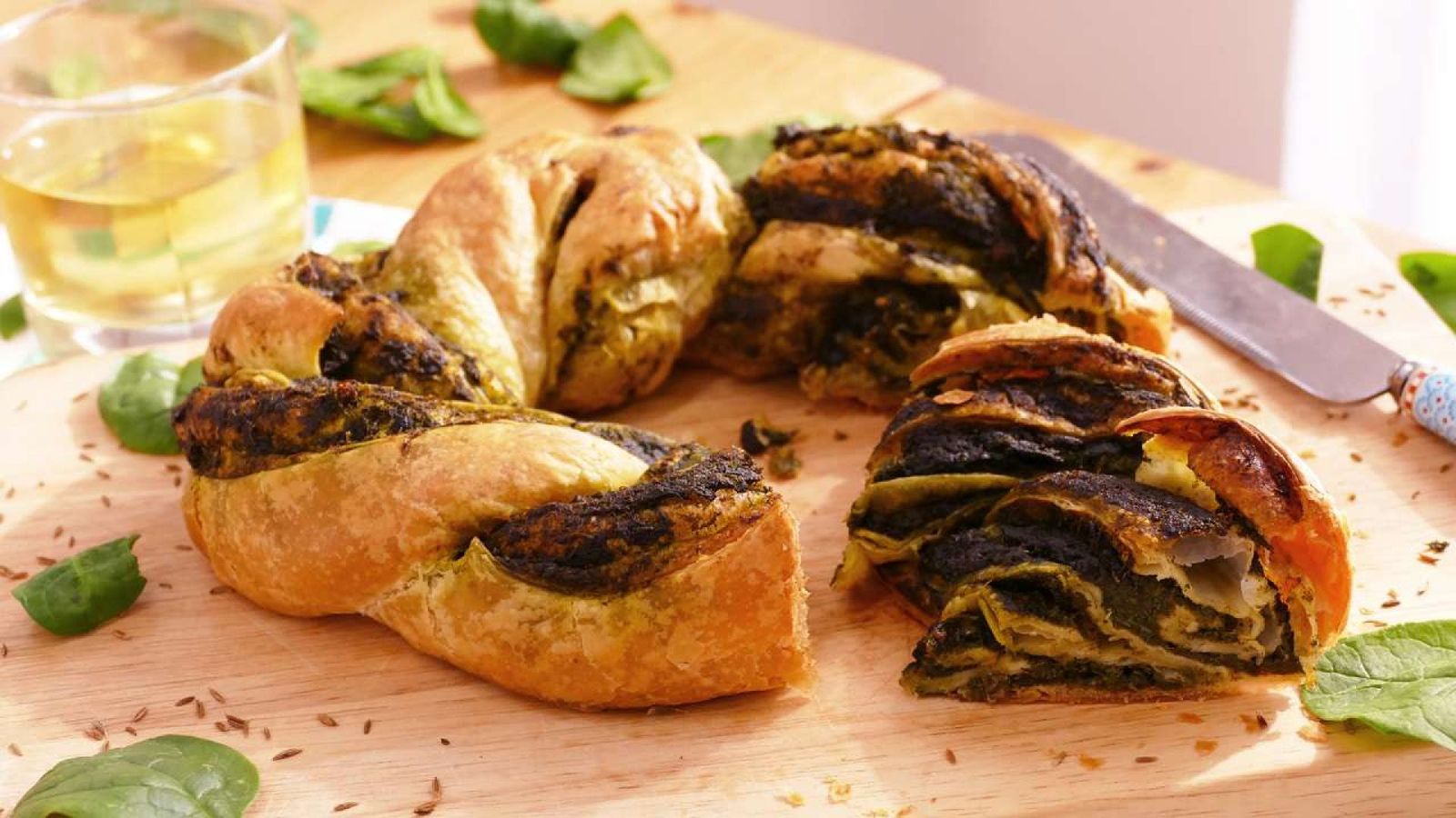 Deliciosa corona de hojaldre trenzado rellena de espinacas, ideal para sorprender en cualquier ocasión