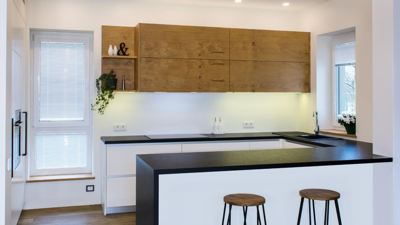 Cocina de estilo industrial con península con encimera en negro.