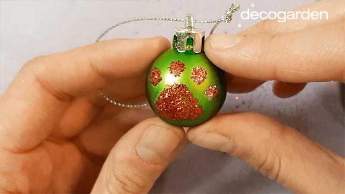 Bola de Navidad verde con huella de mascota.