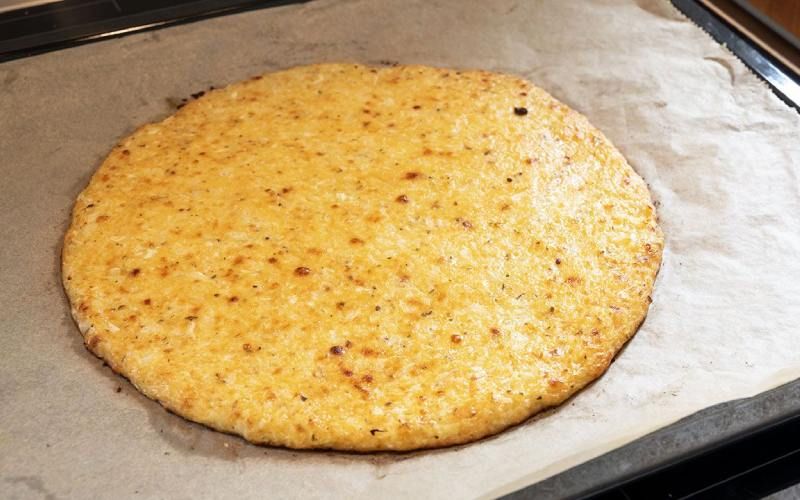 Hornea la masa de pizza de coliflor durante 20 minutos o hasta que veas dorados los bordes