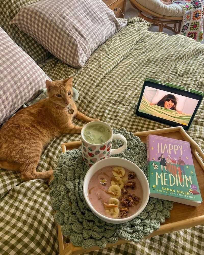 Un gatito sobre una cama de cuadros verdes campestres.
