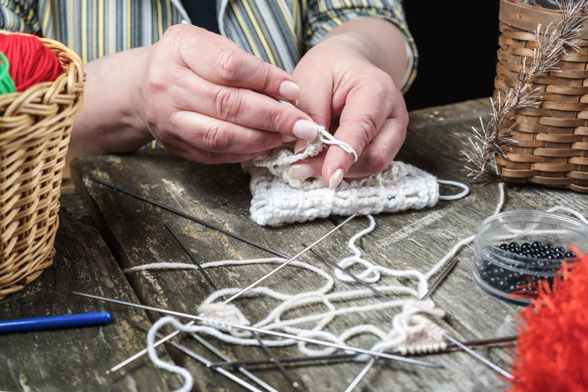 Mujer tejiendo una labor de crochet.