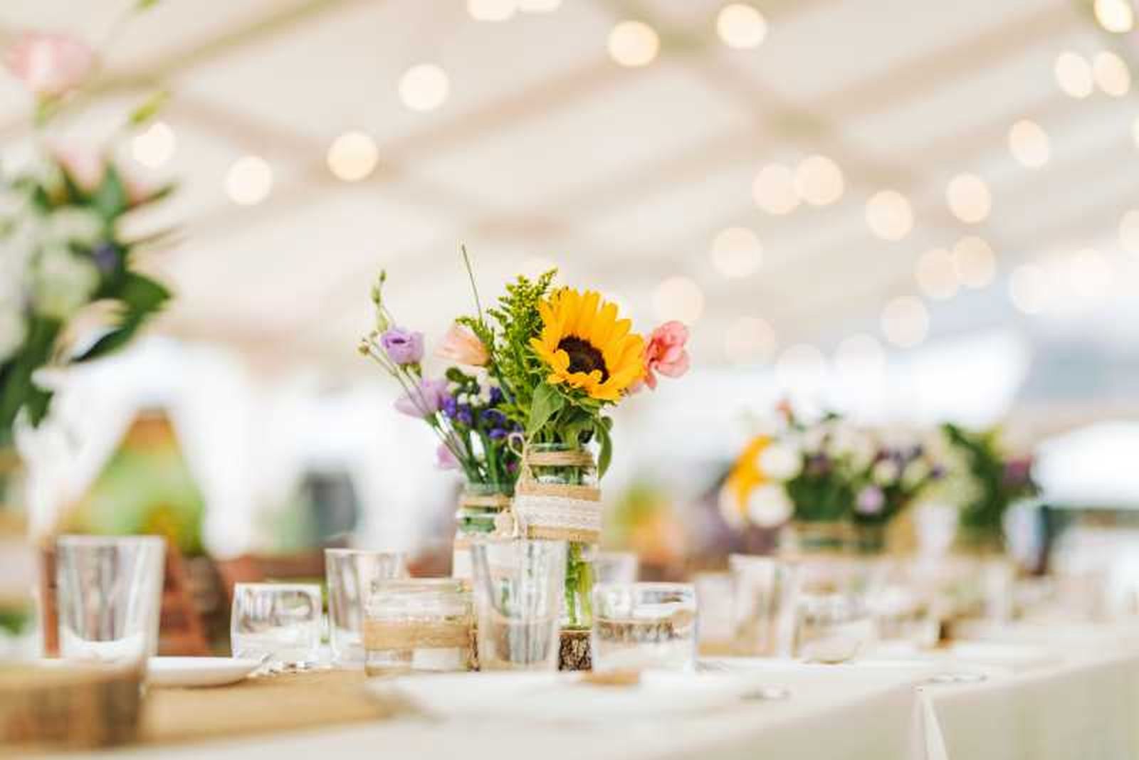 Centro de mesa para boda con girasoles y flores frescas.