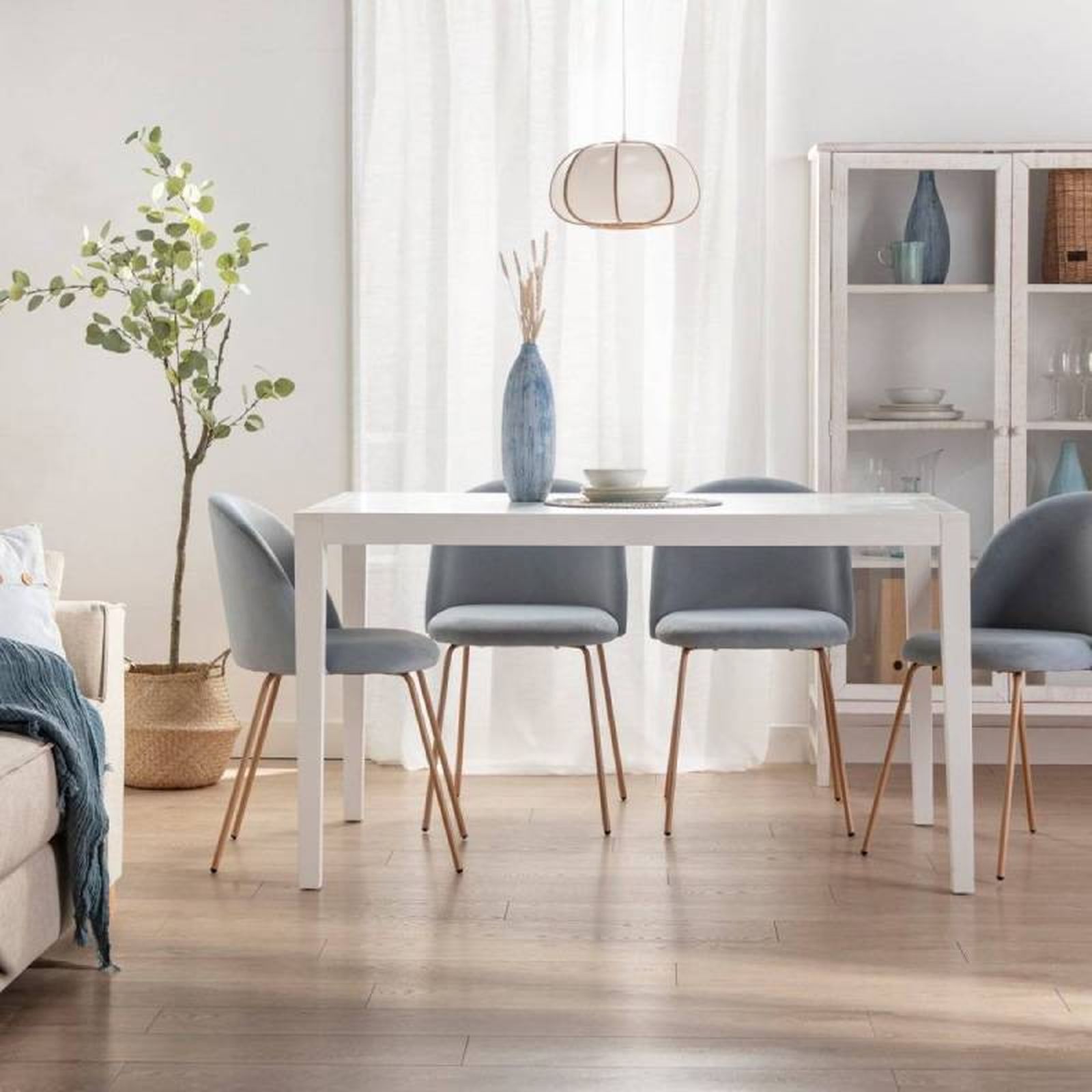 Comedor elegante en azul con mesa rectangular blanca.