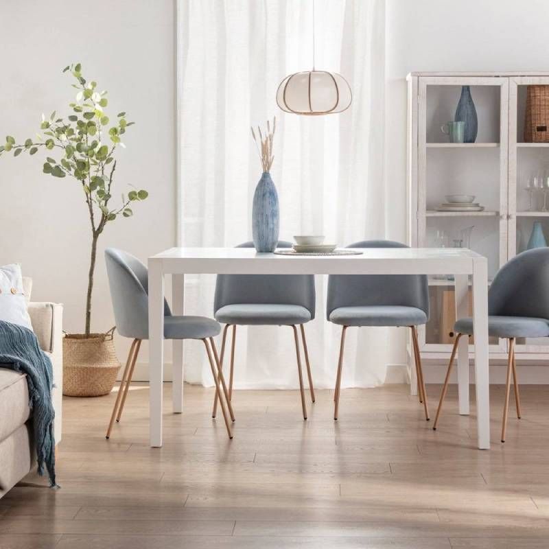 Comedor elegante en azul con mesa rectangular blanca.