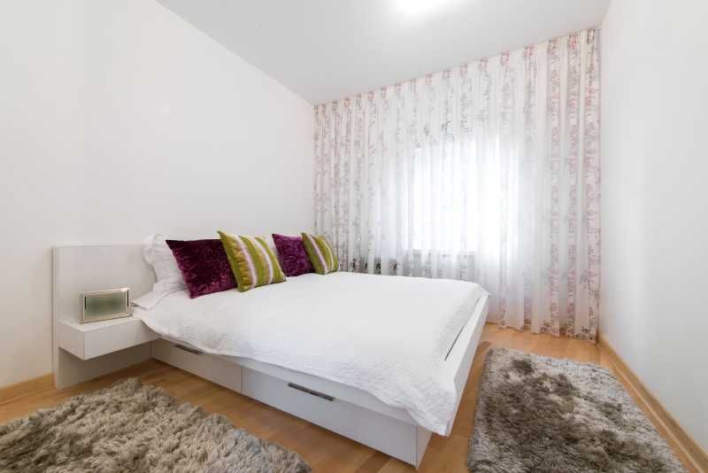 Dormitorio pequeño con mesilla de noche flotante.
