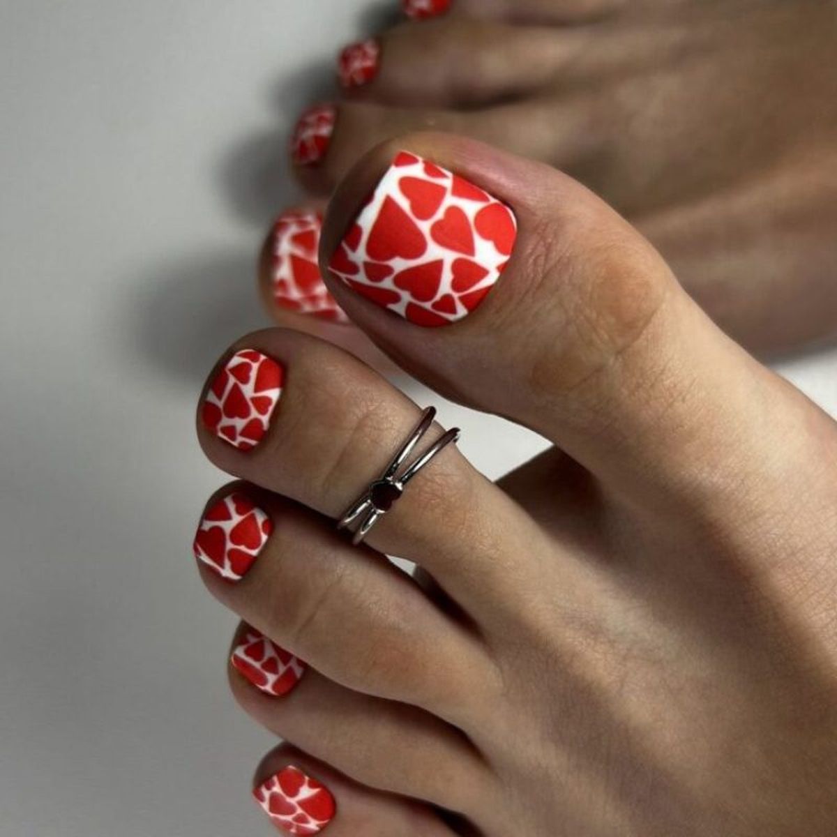 Pedicura blanca con corazones rojos