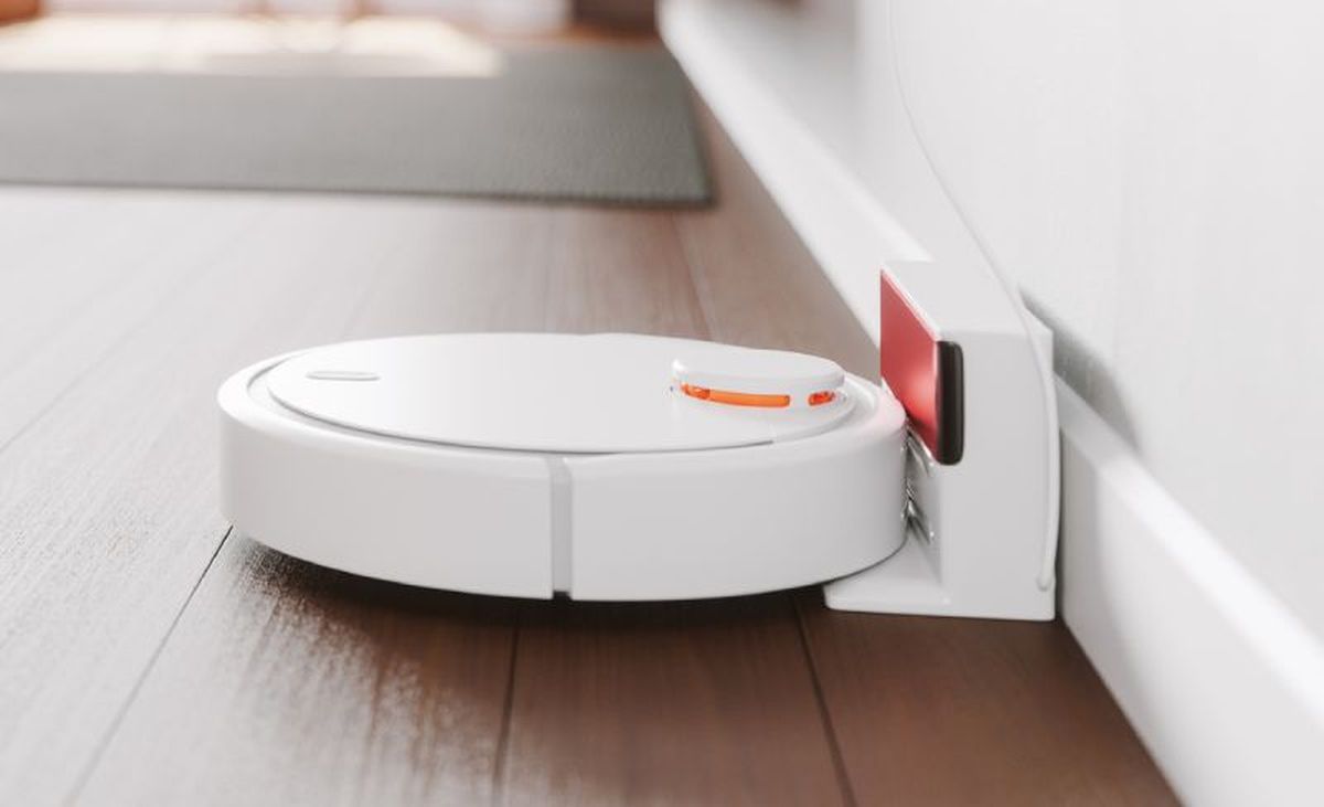 Robot aspirador blanco conectado a su base