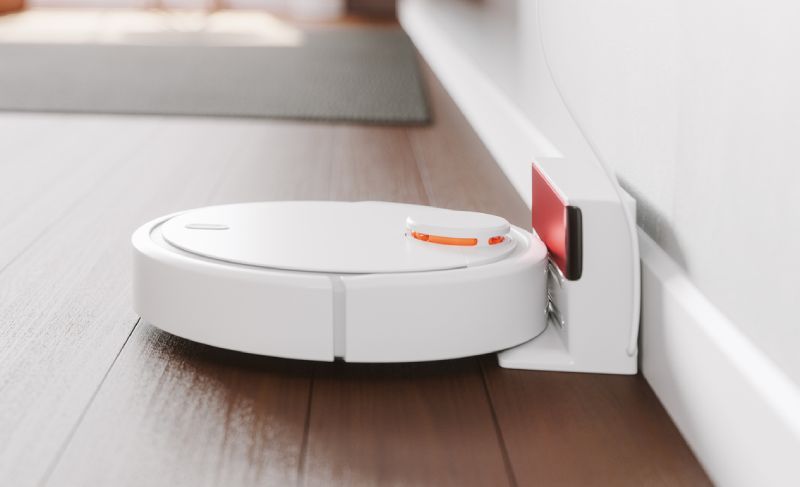 Robot aspirador blanco conectado a su base