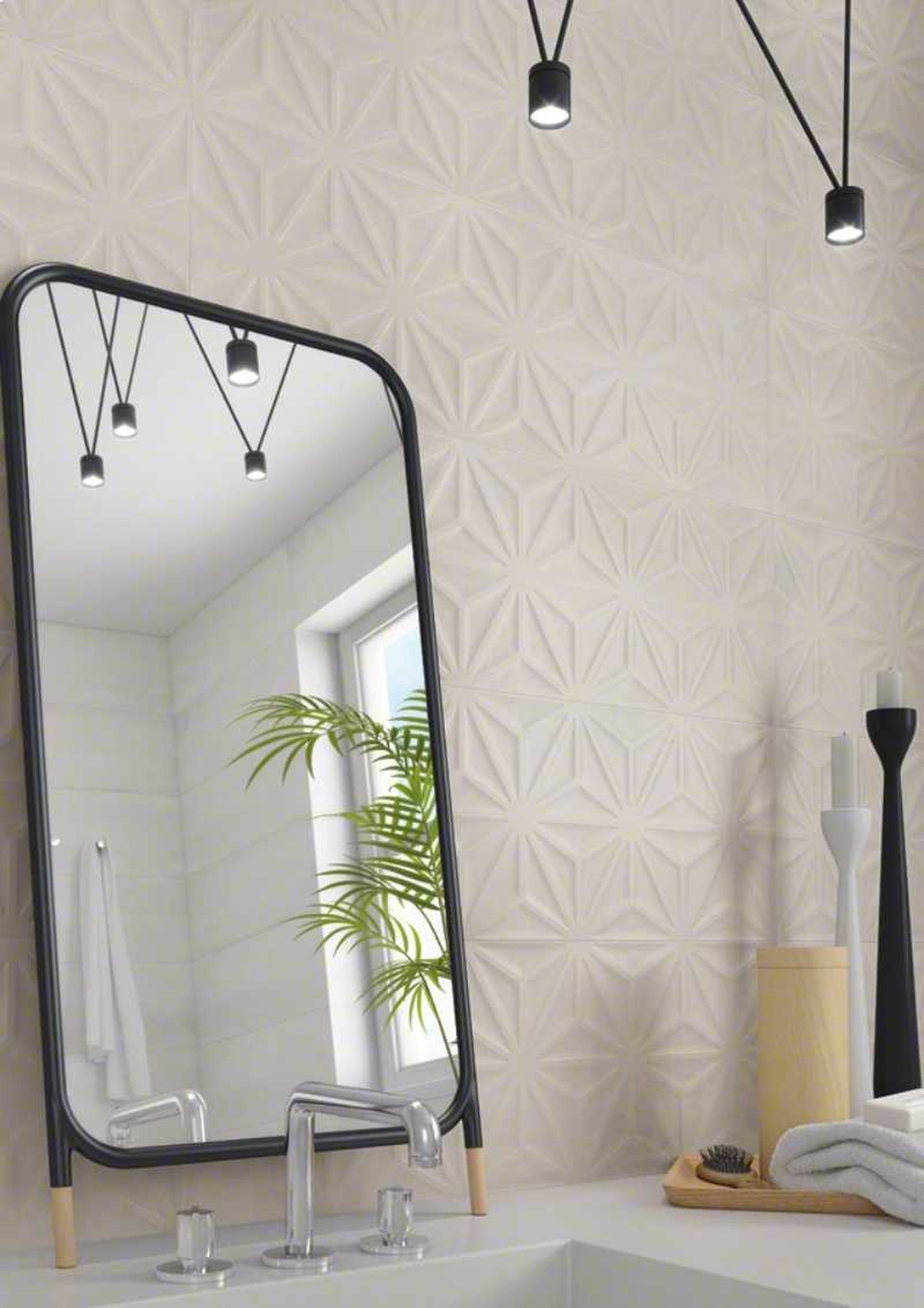 Baño con azulejos geométricos blancos.